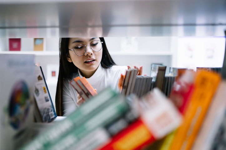 Librarian selecting books from a shelf
