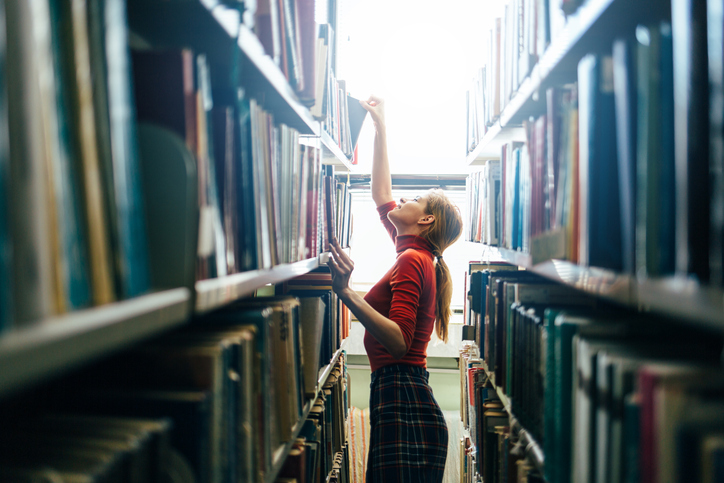 Librarian searching the shelves for a research book